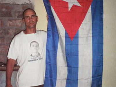 Fuente: Público. Wilman Villar Mendoza junto a la bandera de Cuba